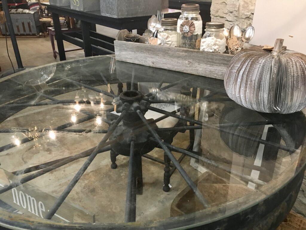 Table made from a wagon wheel with a glass top
