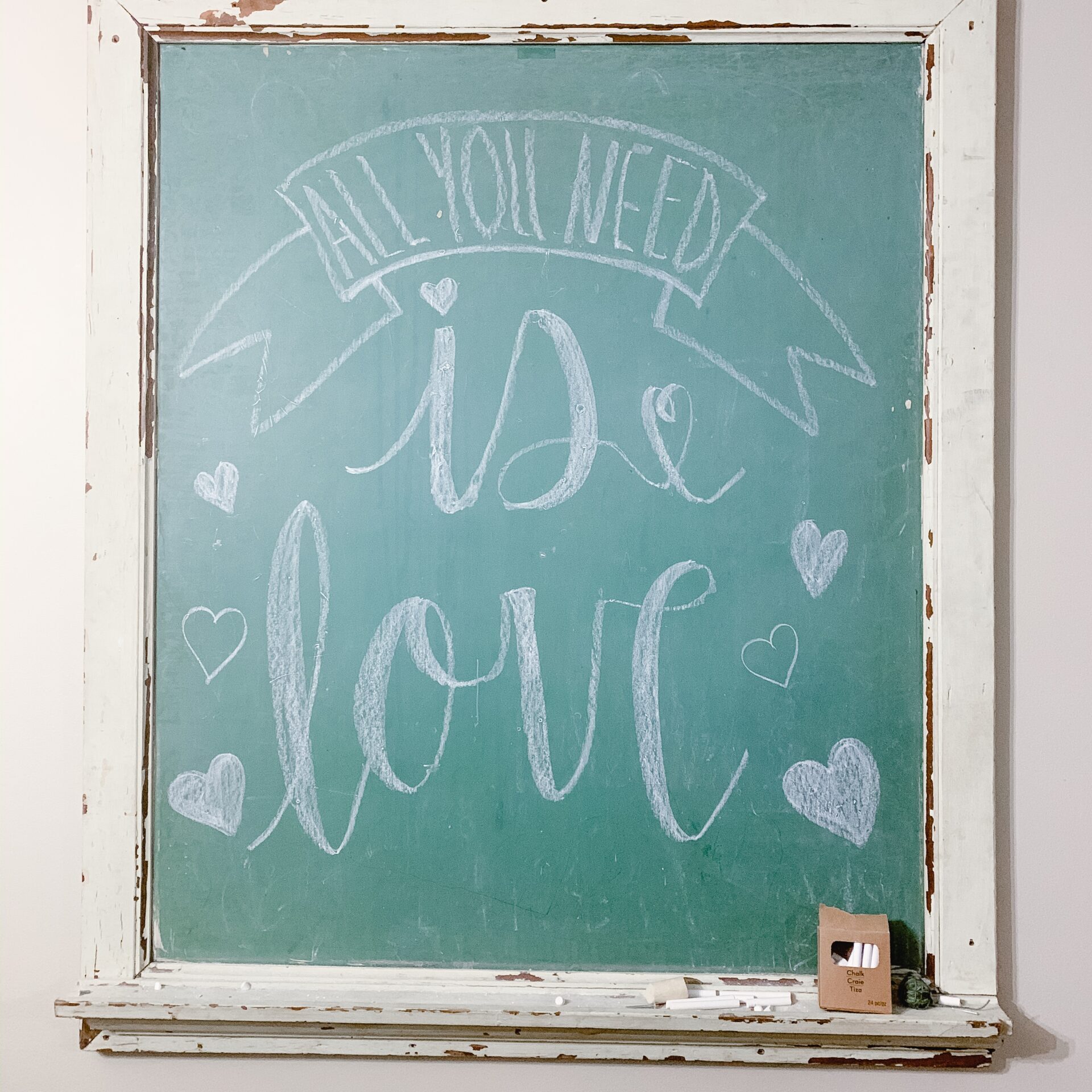 Antique chalkboard with All you need is love hand lettered