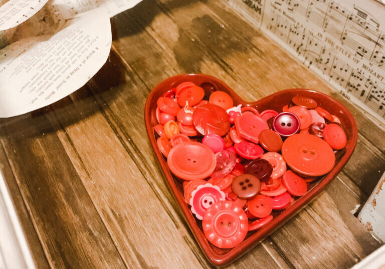 Heart shaped candy dish full of red vintage buttons for Valentine's Day decor